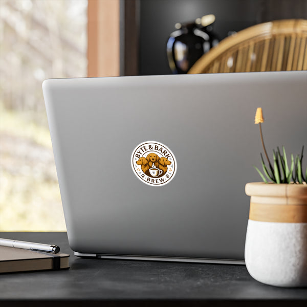 Laptop with a "Byte & Bark Brew" sticker on a desk with a blurred background