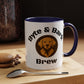 White mug with blue interior and handle, featuring a dog logo and text, on a wooden surface with coffee beans and a spoon.
