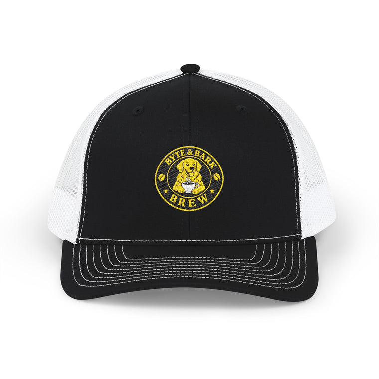 Front view of black and white trucker cap with embroidered Byte & Bark Brew® golden retriever patch