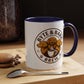 White mug with blue interior and handle, featuring 'Byte & Bark Brew' logo on a wooden surface with coffee beans and a macaron.