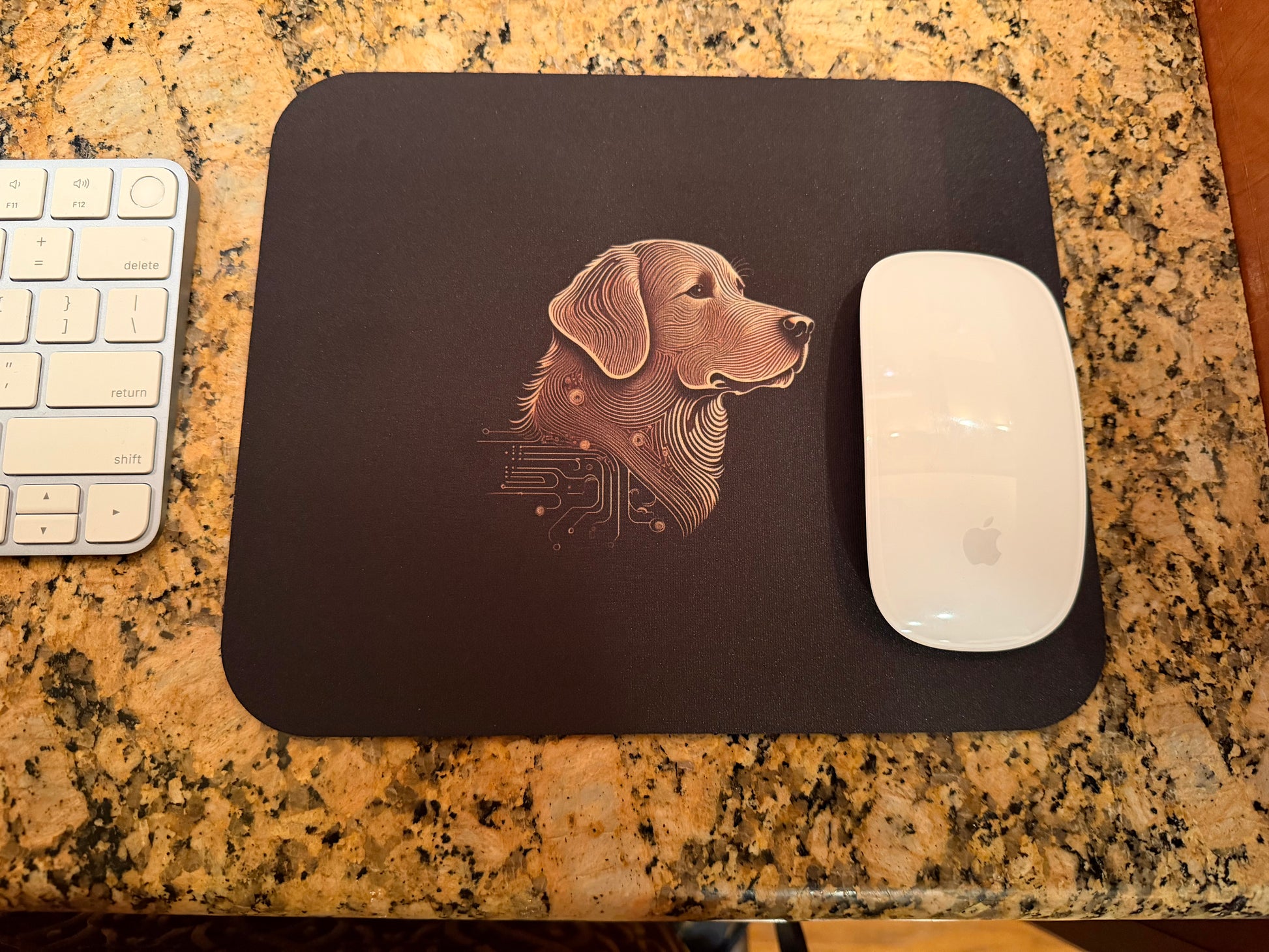 Mouse pad with a dog design on a desk next to a keyboard and mouse.