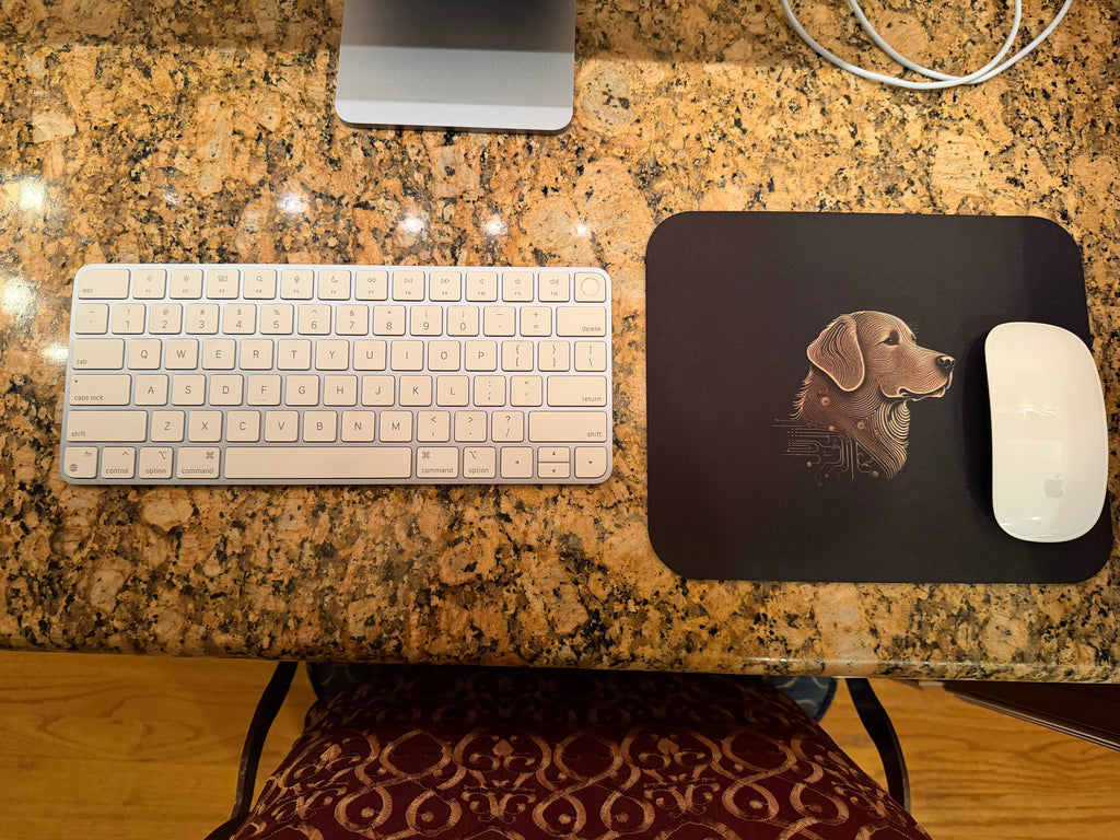 Keyboard, mouse, and mouse pad with a dog design on a granite countertop.