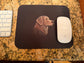 Mouse pad with a dog design on a desk next to a keyboard and mouse.