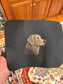 'Byte & Bark Brew' Black mouse pad with a dog illustration held by a hand in a kitchen setting