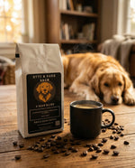 Bag of Byte & Bark Brew coffee and a mug of coffee on a wooden table with a dog in the background.