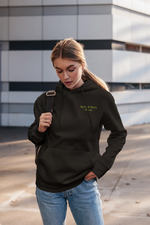 Person wearing a black hoodie with text, standing outdoors.