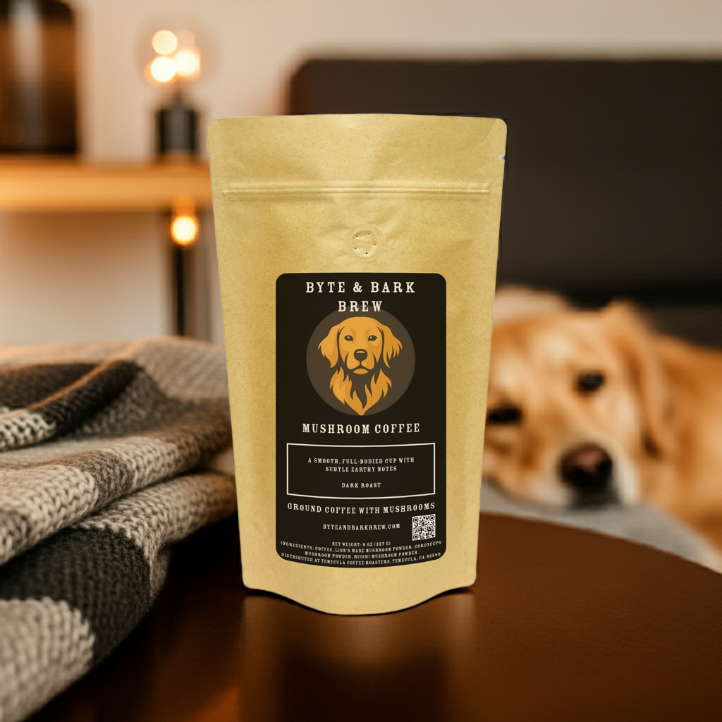 Bag of Byte & Bark Brew Mushroom Coffee Dark Roast on a table with a blanket, while a dog lays on a bed in the background — cozy comfort for dog lovers and coffee drinkers.